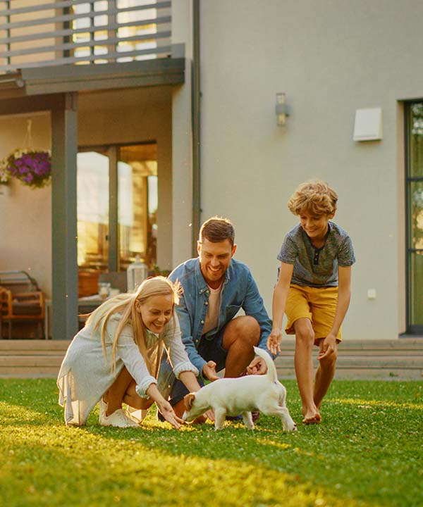 Family playing with their puppy on their backyard.